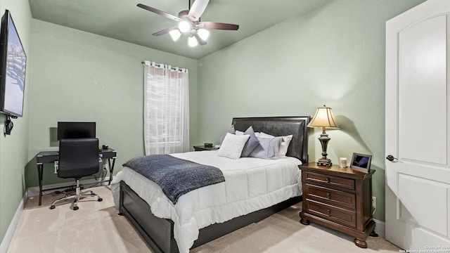 bedroom featuring a ceiling fan, light colored carpet, and baseboards