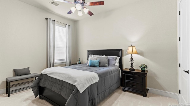 bedroom with light carpet, ceiling fan, visible vents, and baseboards