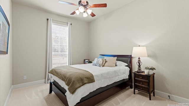 bedroom with light carpet, ceiling fan, and baseboards