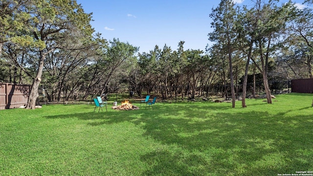 view of yard featuring a fire pit and fence