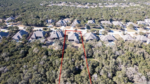 drone / aerial view featuring a residential view and a wooded view