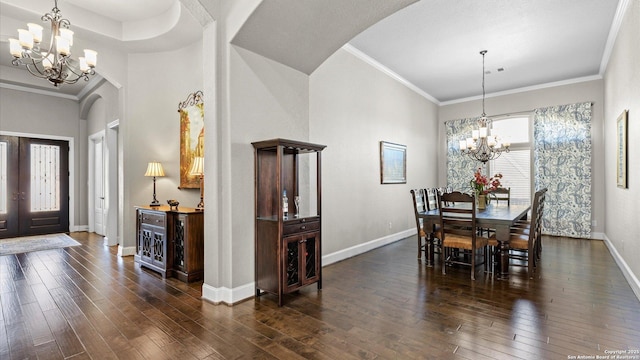 dining space featuring baseboards, arched walkways, dark wood-style floors, ornamental molding, and a notable chandelier