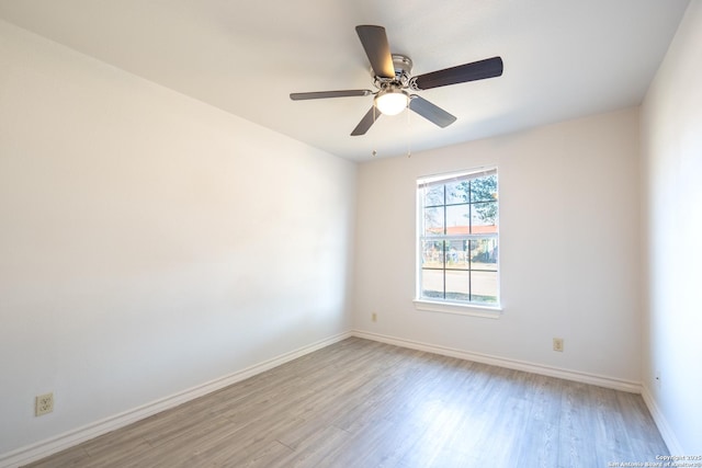 empty room featuring a ceiling fan, light wood-style flooring, and baseboards