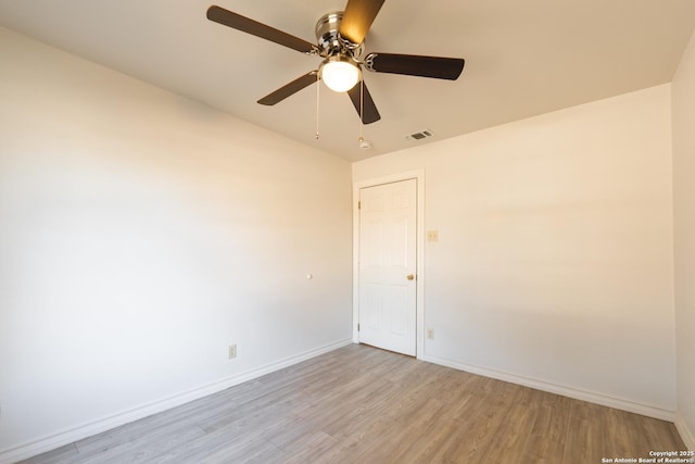 spare room featuring visible vents, light wood-style flooring, and baseboards