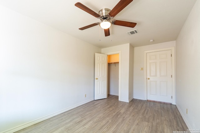 unfurnished bedroom with light wood-type flooring, baseboards, visible vents, and a closet