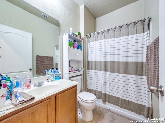 bathroom with visible vents, toilet, a textured ceiling, vanity, and tile patterned floors