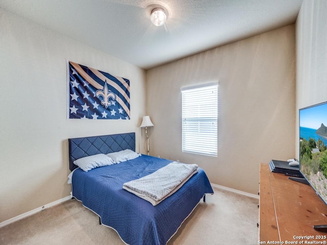 bedroom featuring light carpet and baseboards