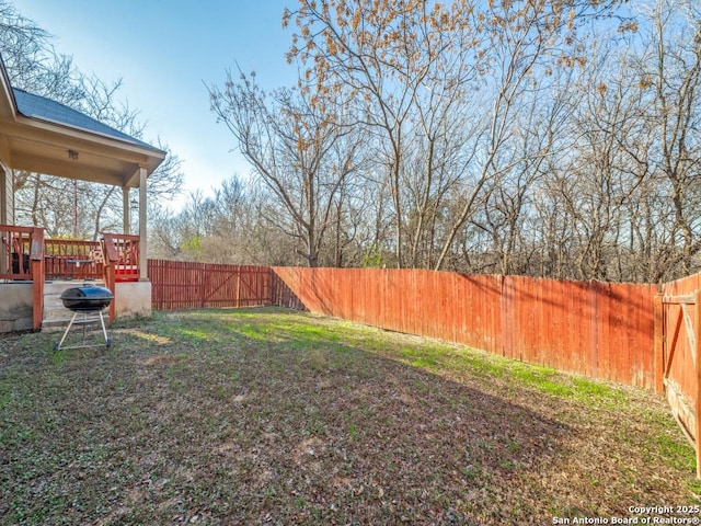 view of yard with a fenced backyard and a wooden deck