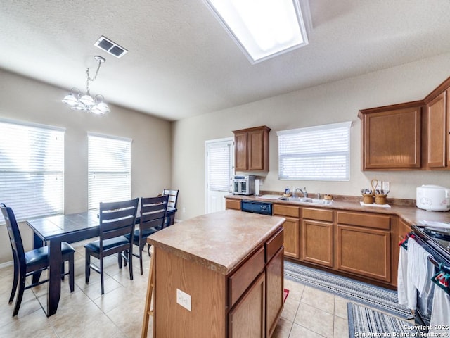 kitchen with a kitchen island, visible vents, electric stove, brown cabinets, and decorative light fixtures