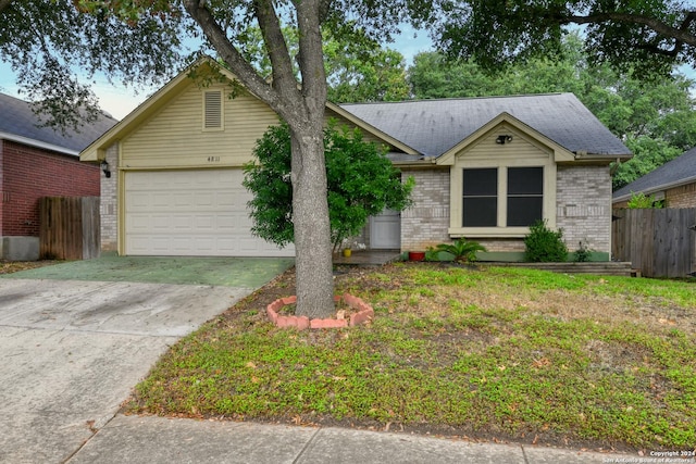 ranch-style house with brick siding, fence, driveway, and an attached garage