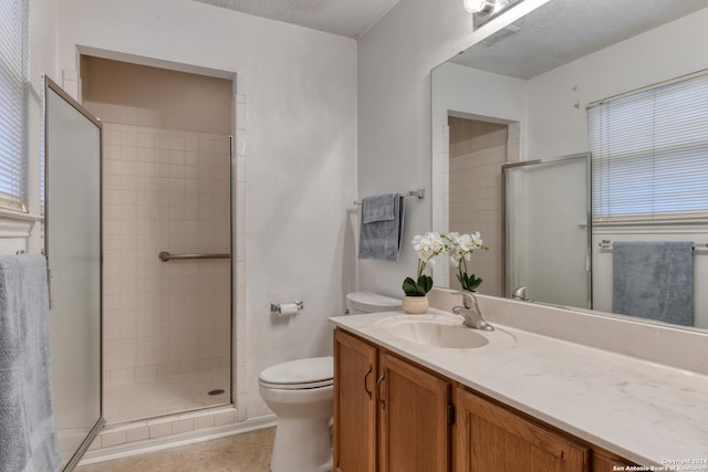 bathroom with toilet, tile patterned floors, a textured ceiling, vanity, and a shower stall