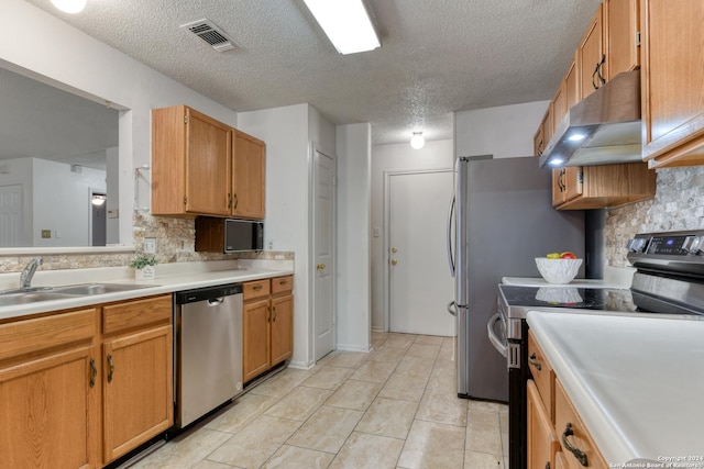 kitchen featuring visible vents, stainless steel appliances, light countertops, under cabinet range hood, and a sink