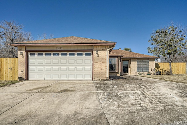 view of front of house featuring concrete driveway, brick siding, fence, and an attached garage