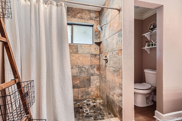 bathroom featuring a textured wall, ornamental molding, a tile shower, and toilet