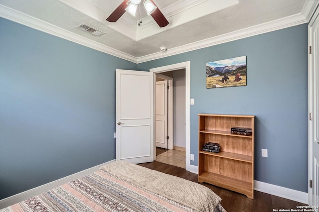 bedroom with dark wood-style flooring, crown molding, visible vents, ceiling fan, and baseboards