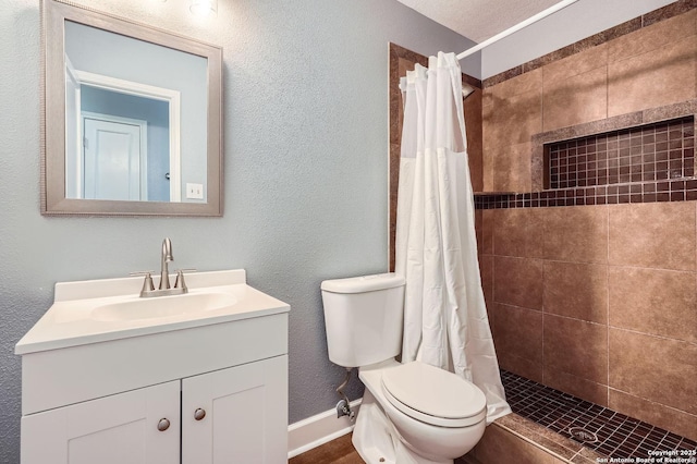 full bathroom with toilet, a textured wall, a tile shower, and vanity