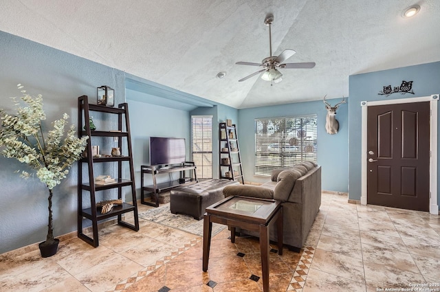 tiled living area with lofted ceiling, ceiling fan, baseboards, and a textured ceiling