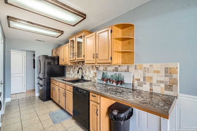 kitchen featuring light tile patterned floors, visible vents, dark countertops, black appliances, and a sink