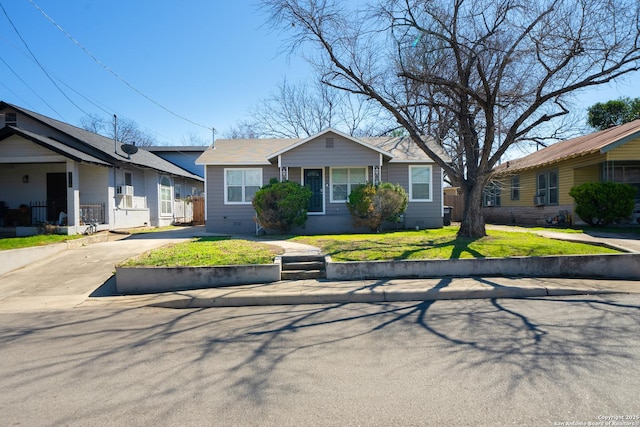 bungalow-style house with crawl space, driveway, and a front lawn