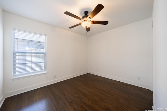 unfurnished room featuring dark wood finished floors, a ceiling fan, and baseboards