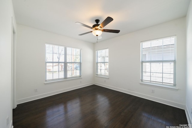 spare room with ceiling fan, dark wood finished floors, and baseboards