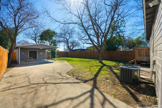 view of yard featuring a fenced backyard, central AC, and a patio