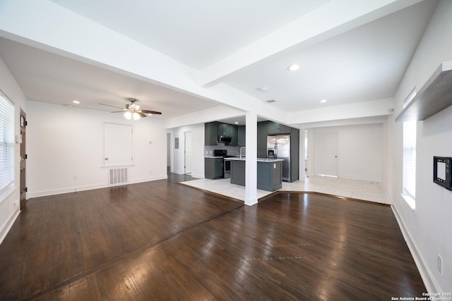 unfurnished living room featuring a healthy amount of sunlight, visible vents, a fireplace, and light wood-style flooring