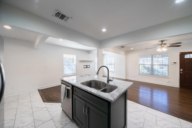 kitchen featuring marble finish floor, visible vents, stainless steel dishwasher, a sink, and baseboards