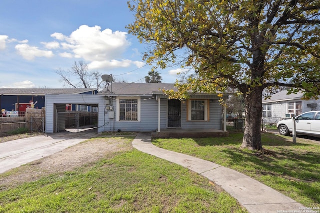 view of front of house with fence, an attached carport, concrete driveway, and a front yard