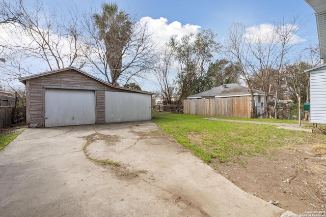 detached garage with fence and driveway