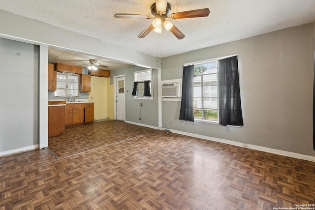 interior space with brown cabinetry, light countertops, a textured ceiling, and baseboards