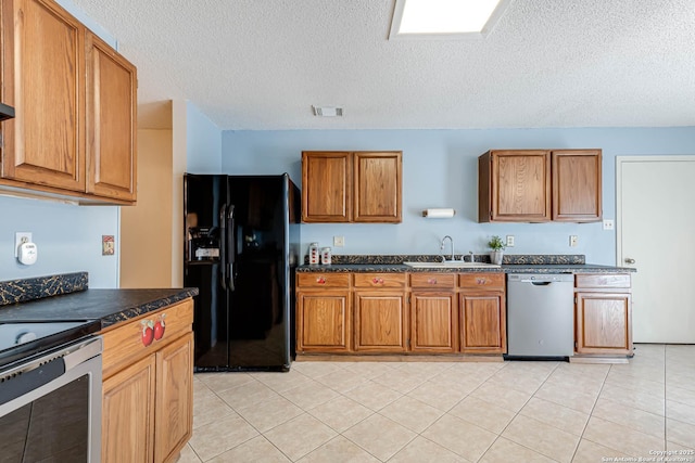 kitchen with appliances with stainless steel finishes, dark countertops, brown cabinets, and a sink