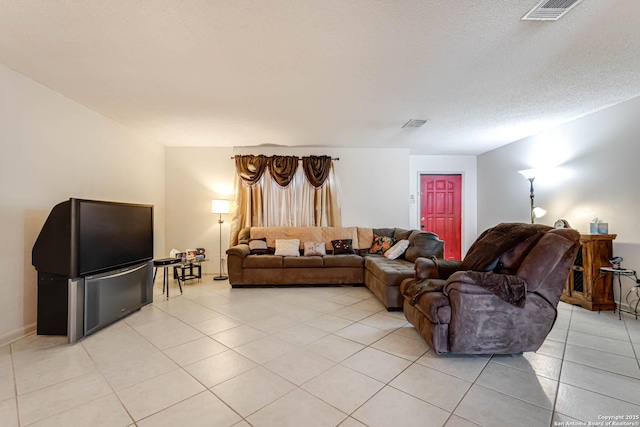 living room with light tile patterned floors, a textured ceiling, and visible vents