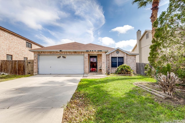 view of front facade with a front yard, driveway, an attached garage, and fence