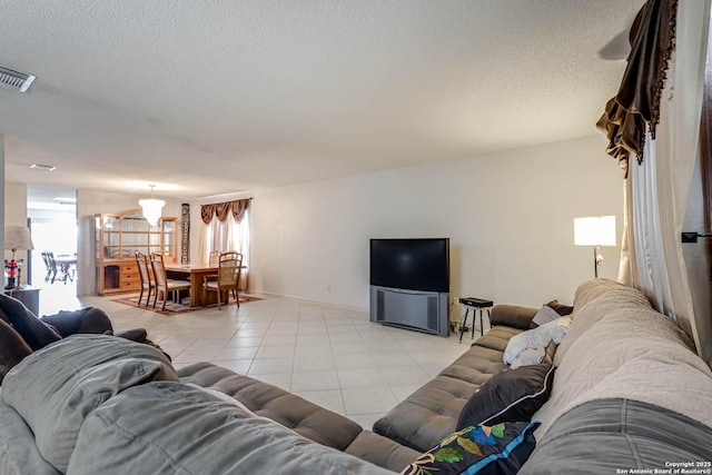 living room featuring plenty of natural light, a textured ceiling, baseboards, and light tile patterned floors