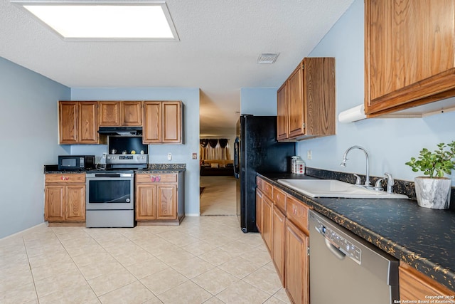 kitchen featuring black appliances, visible vents, brown cabinetry, and a sink