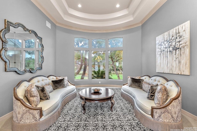 sitting room featuring ornamental molding, a raised ceiling, visible vents, and baseboards