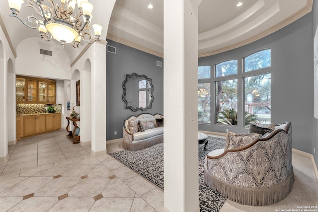 dining area with light tile patterned floors, visible vents, arched walkways, and baseboards