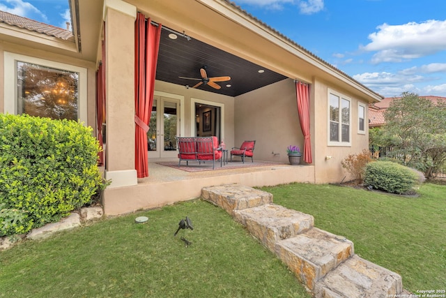 exterior space featuring ceiling fan, a yard, french doors, stucco siding, and a patio area