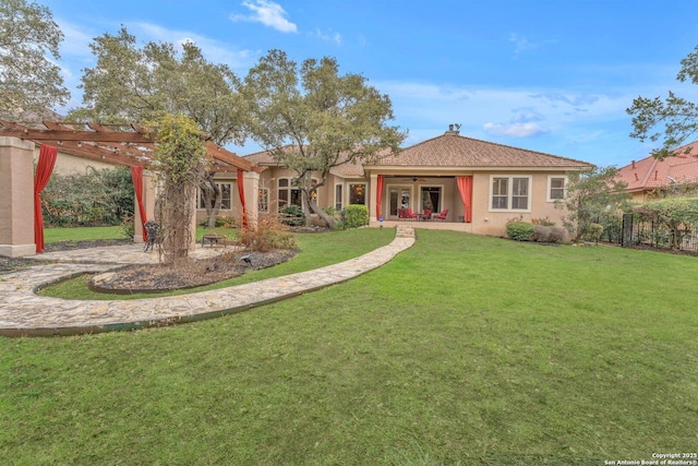 view of front of property featuring a ceiling fan, a patio area, a front lawn, a pergola, and stucco siding