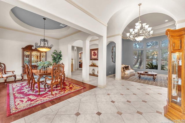 tiled dining room with arched walkways, baseboards, ornamental molding, a tray ceiling, and an inviting chandelier