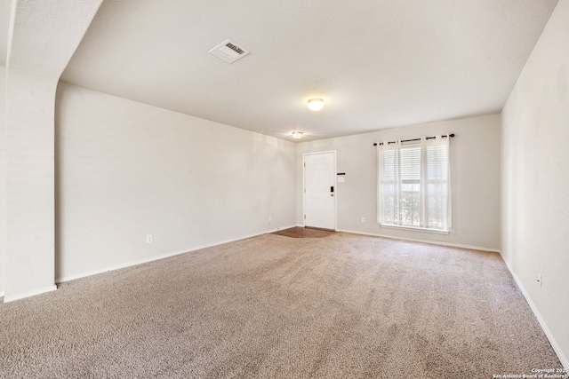 spare room with baseboards, visible vents, and carpet flooring