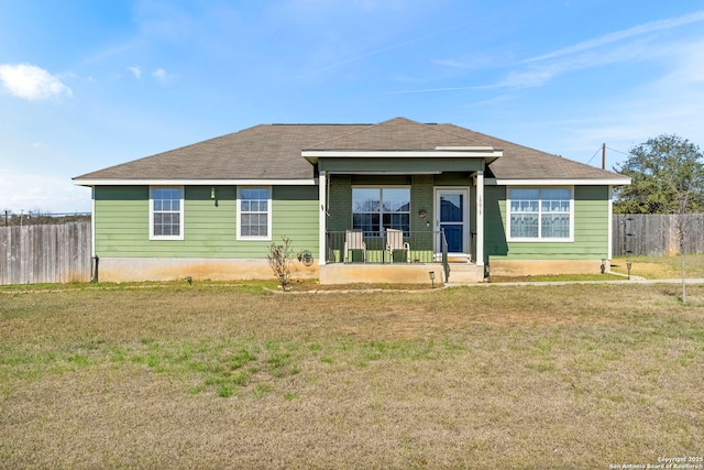 view of front facade with covered porch, fence, and a front lawn