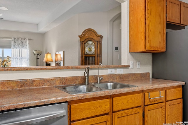 kitchen with stainless steel appliances, light countertops, brown cabinets, and a sink