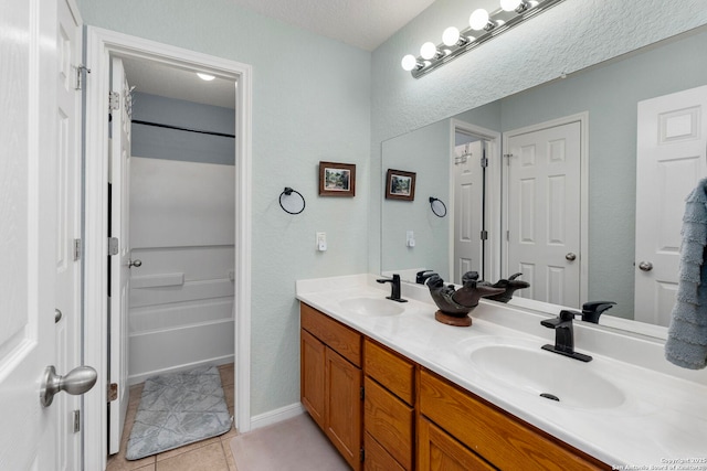 bathroom with double vanity, a sink, and tile patterned floors