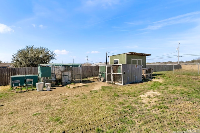 view of yard featuring a fenced backyard, exterior structure, and an outdoor structure