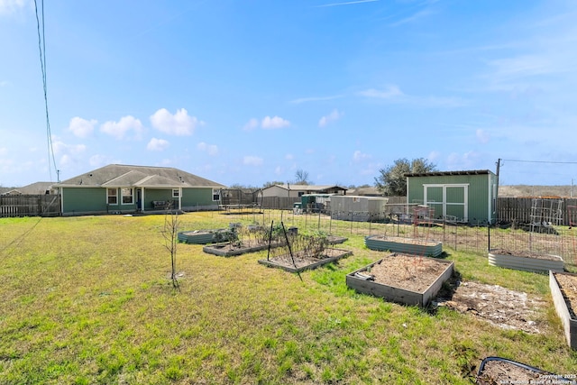 view of yard with a vegetable garden, an outdoor structure, and fence