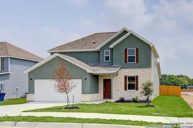 view of front of home with concrete driveway, stone siding, an attached garage, fence, and stucco siding