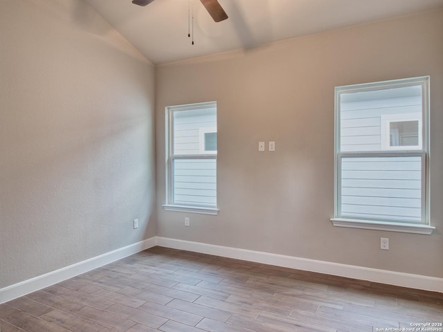 empty room featuring a ceiling fan, baseboards, vaulted ceiling, and wood finished floors