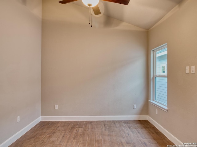 unfurnished room with light wood-style flooring, baseboards, and vaulted ceiling